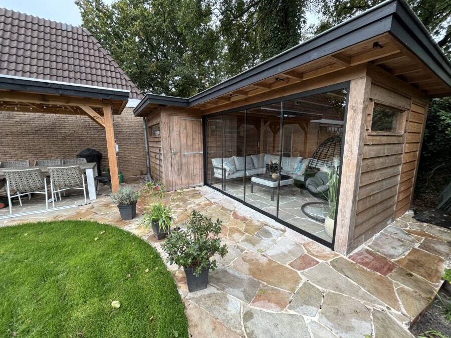 In een tuin met zuidelijke sferen en rustieke bestrating kun je de zon en geur proeven.